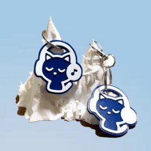 NFC and non-NFC blue cat headphones keychains displayed on a white 3D printed mountain stand